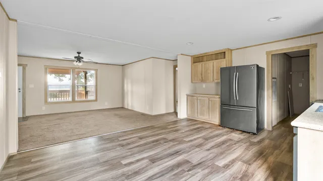 a view of a kitchen with a sink refrigerator and wooden floor