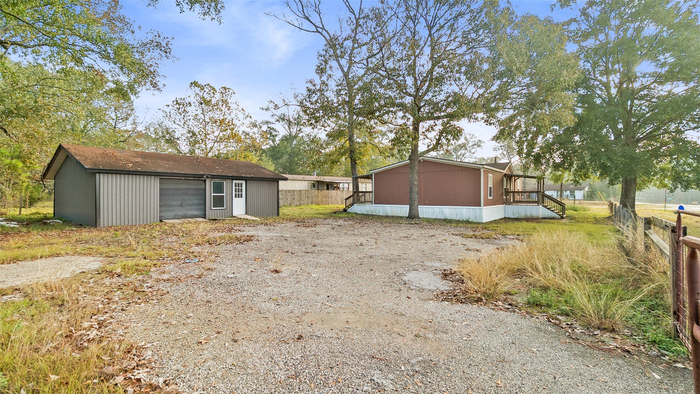 10499 Highway 156 Coldspring, TX 77331 - Photo 3 of 45 a backyard of a house with large trees and wooden fence