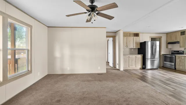a view of a kitchen with a refrigerator and a ceiling fan