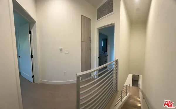 a view of a hallway with wooden floor and staircase