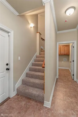 a view of a hallway with staircase and white walls