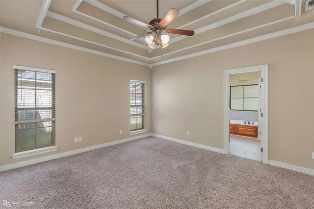 an empty room with windows and ceiling fan