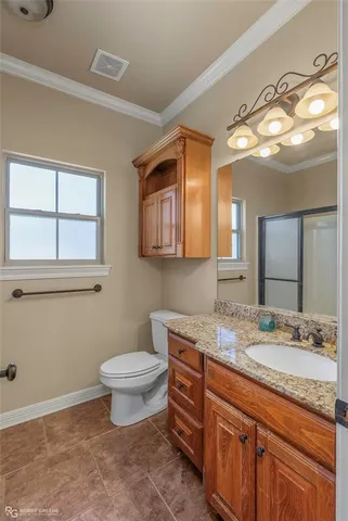a bathroom with a granite countertop toilet sink and mirror