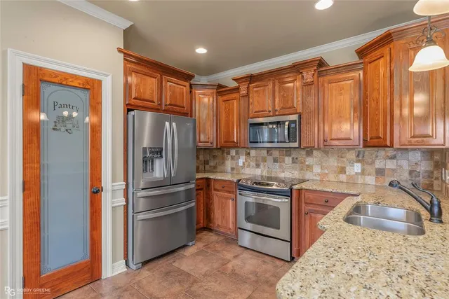 a kitchen with stainless steel appliances granite countertop a refrigerator stove top oven and sink