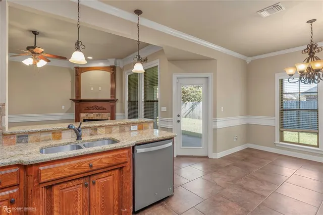 a kitchen with granite countertop a sink and a refrigerator