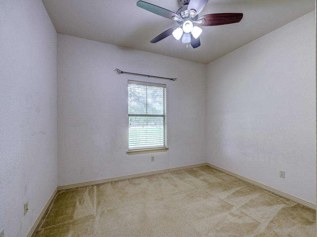 9707 Anderson Mill Road, Unit 22 Austin, TX 78750 - Photo 22 of 39 A well-lit bedroom features plush carpet and a convenient ceiling fan for comfort.