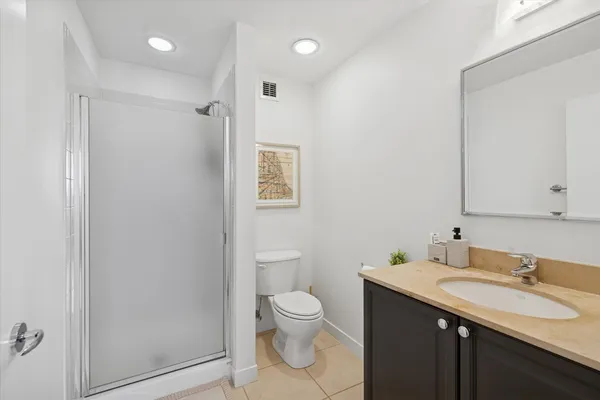a bathroom with a granite countertop sink a toilet and a mirror
