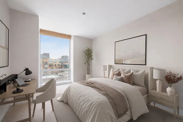 a bedroom with a bed and a large window