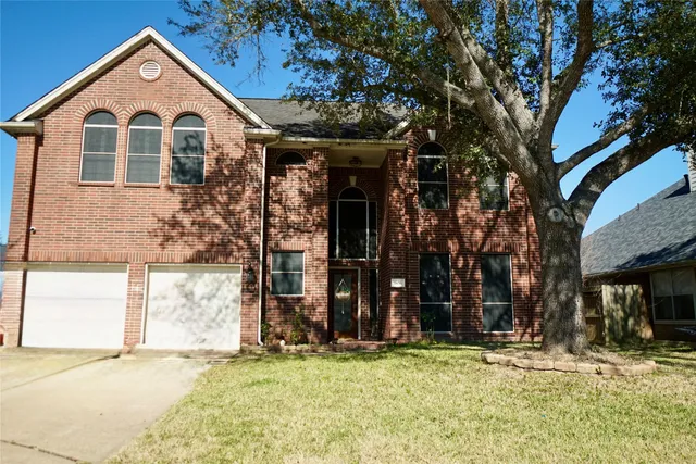 a view of a house with large windows and a tree