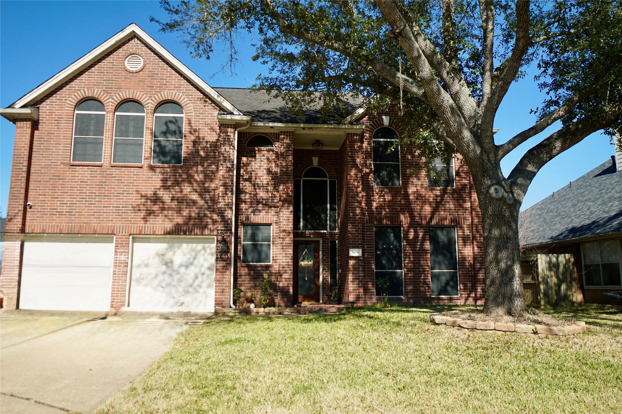 a view of a house with large windows and a tree