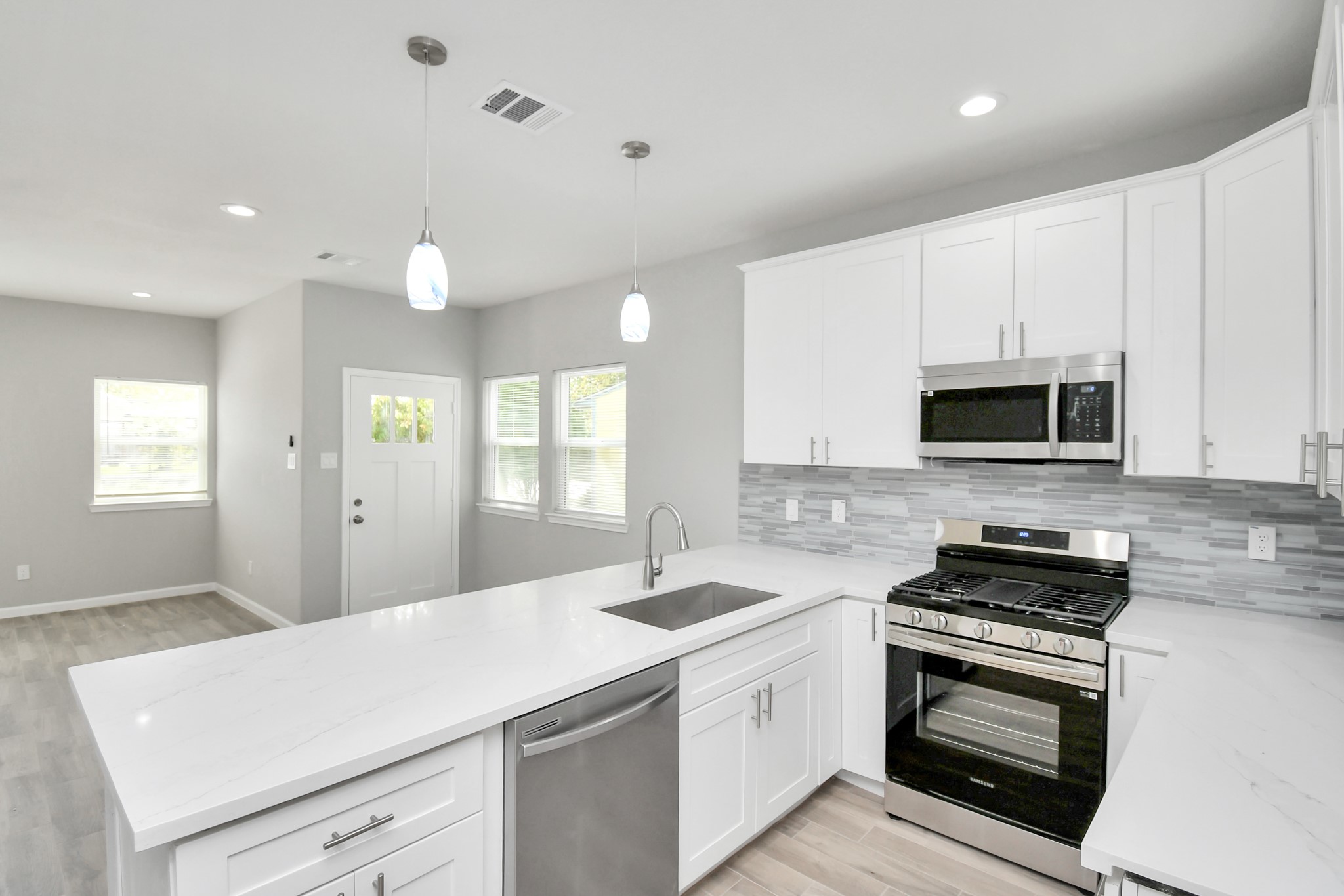 5941 Southlea Street Houston, TX 77033 - Photo 13 of 31 a kitchen with granite countertop white cabinets and stainless steel appliances