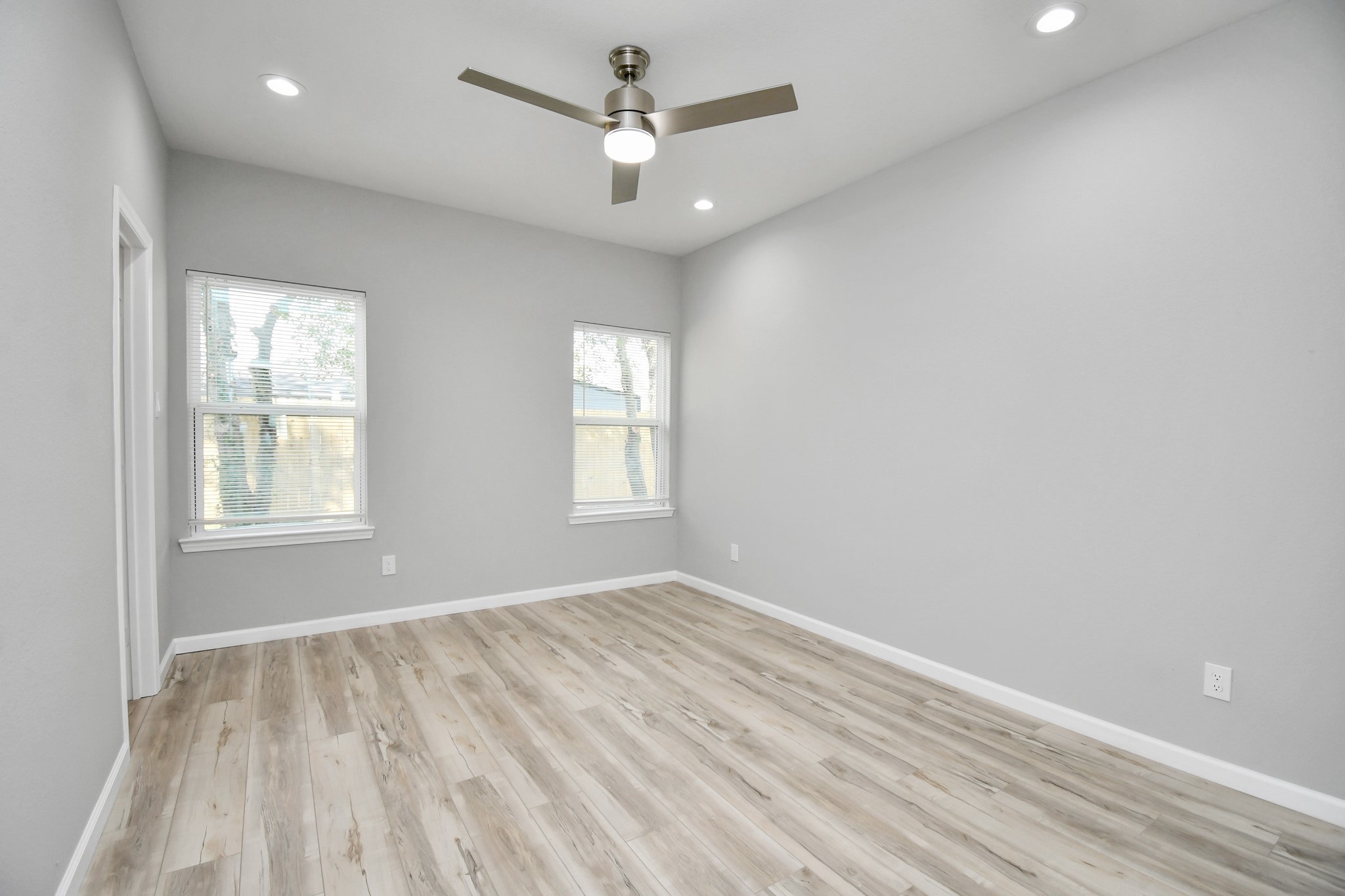5941 Southlea Street Houston, TX 77033 - Photo 21 of 31 an empty room with windows and ceiling fan