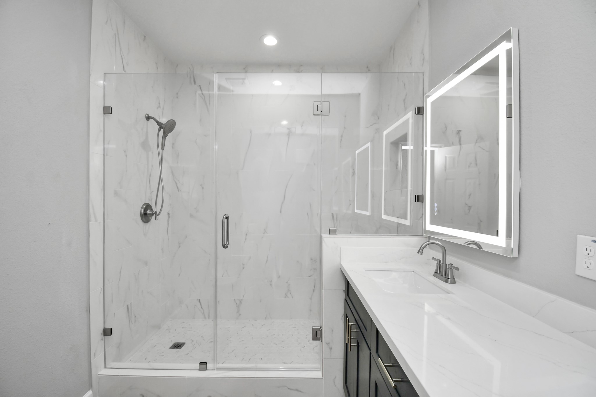 5941 Southlea Street Houston, TX 77033 - Photo 22 of 31 a bathroom with a shower sink and mirror
