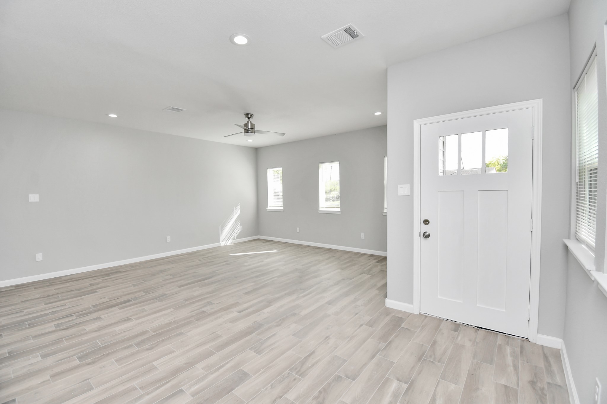 5941 Southlea Street Houston, TX 77033 - Photo 7 of 31 an empty room with wooden floor and windows