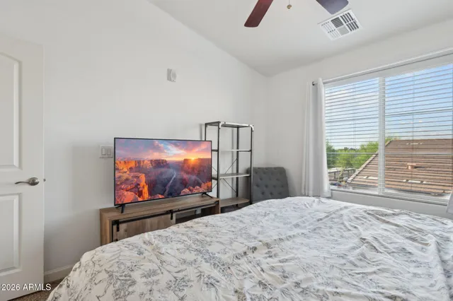a bedroom with a bed and a flat screen tv