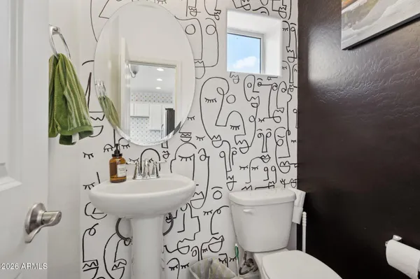 a bathroom with a toilet sink and mirror