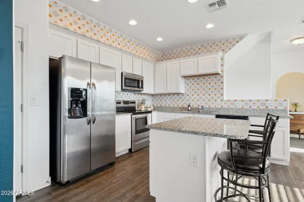a kitchen with kitchen island granite countertop a sink stove and refrigerator
