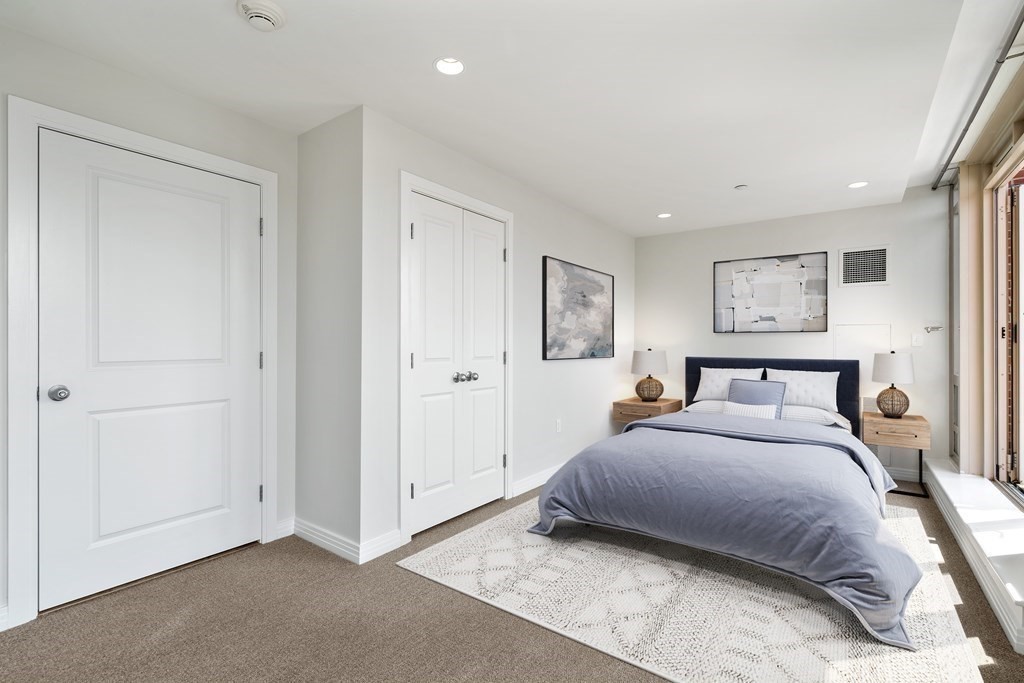 1910 Dorchester Avenue, Unit 601 Boston, MA 02124 - Photo 4 of 15 a spacious bedroom with a bed and a painting on the wall