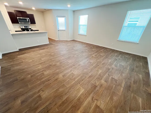a view of an empty room and wooden floor