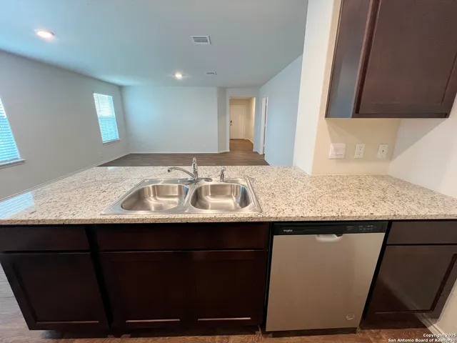 a kitchen with stainless steel appliances wooden cabinets and a stove top oven