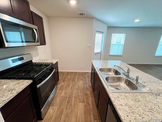 a view of a kitchen with wooden floor and staircase