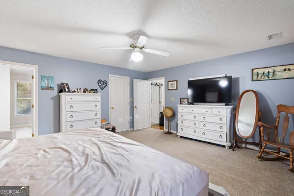 a living room with furniture a flat screen tv and kitchen view