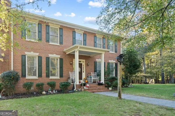 front view of a brick house with a yard