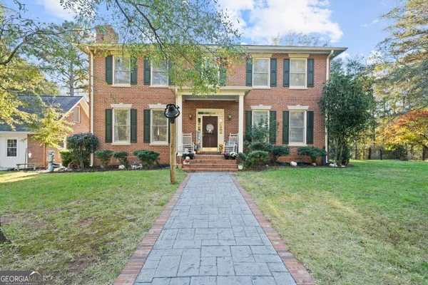 front view of a brick house with a yard