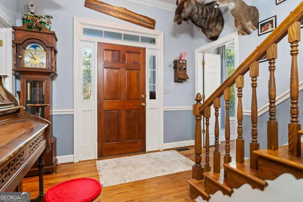 a view of an entryway with wooden floor and a front door