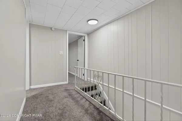 a view of hallway with stairs and wooden floor