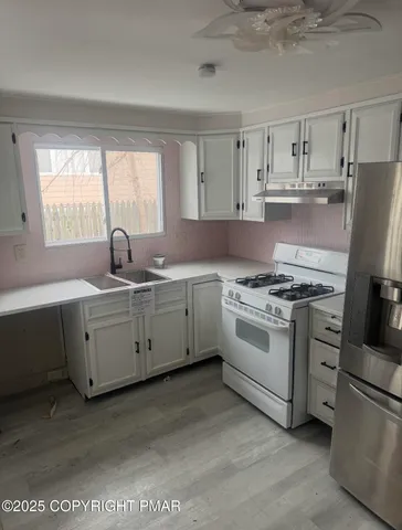 a kitchen with cabinets appliances and a window