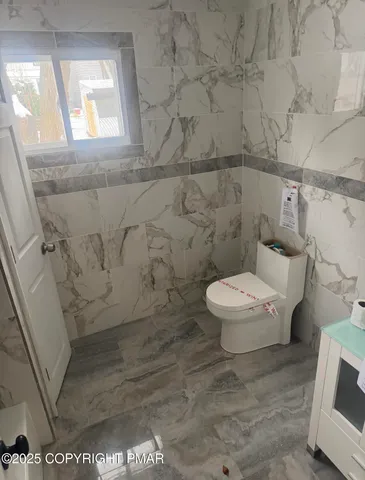 a white toilet sitting next to a bath tub