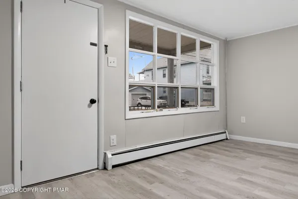an empty room with wooden floor and windows
