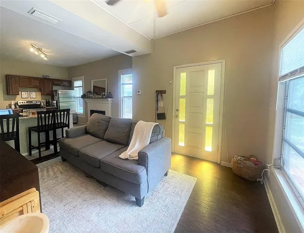 a living room with furniture and a wooden floor