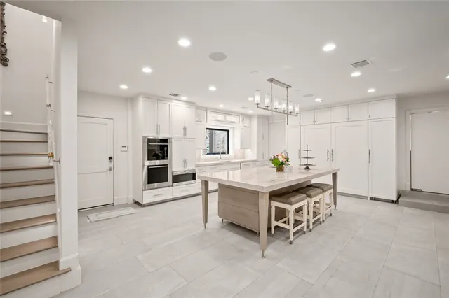 a living room with stainless steel appliances kitchen island granite countertop a stove and a refrigerator