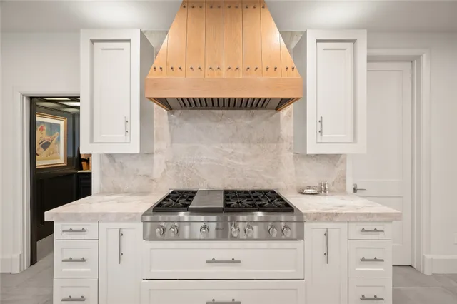 a kitchen with granite countertop a stove and a white cabinet