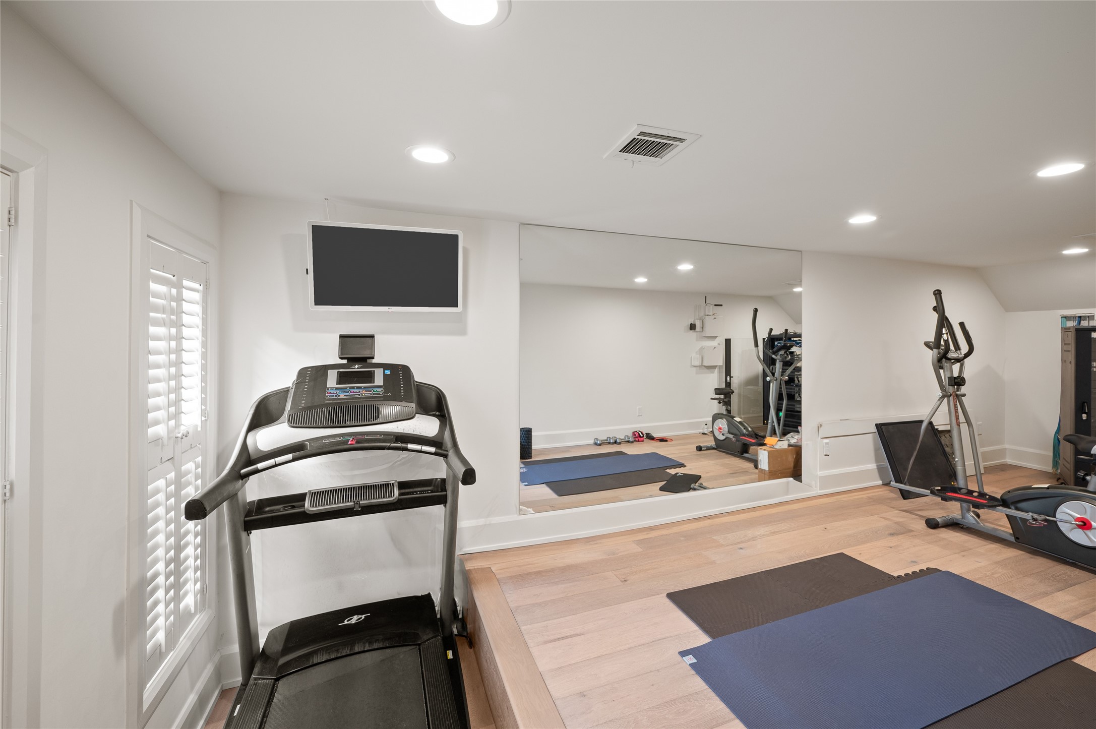 11518 Shadow Way Street Houston, TX 77024 - Photo 30 of 50 a room with gym equipment and a flat screen tv