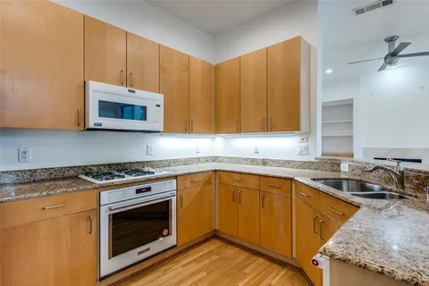 a kitchen with stainless steel appliances granite countertop wooden cabinets stove top oven and sink