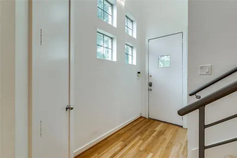 a view of an empty room with window and wooden floor