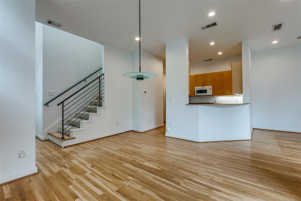 4302 Gilbert Avenue Dallas, TX 75219 - Photo 6 of 28 a view of an empty room with wooden floor and stairs