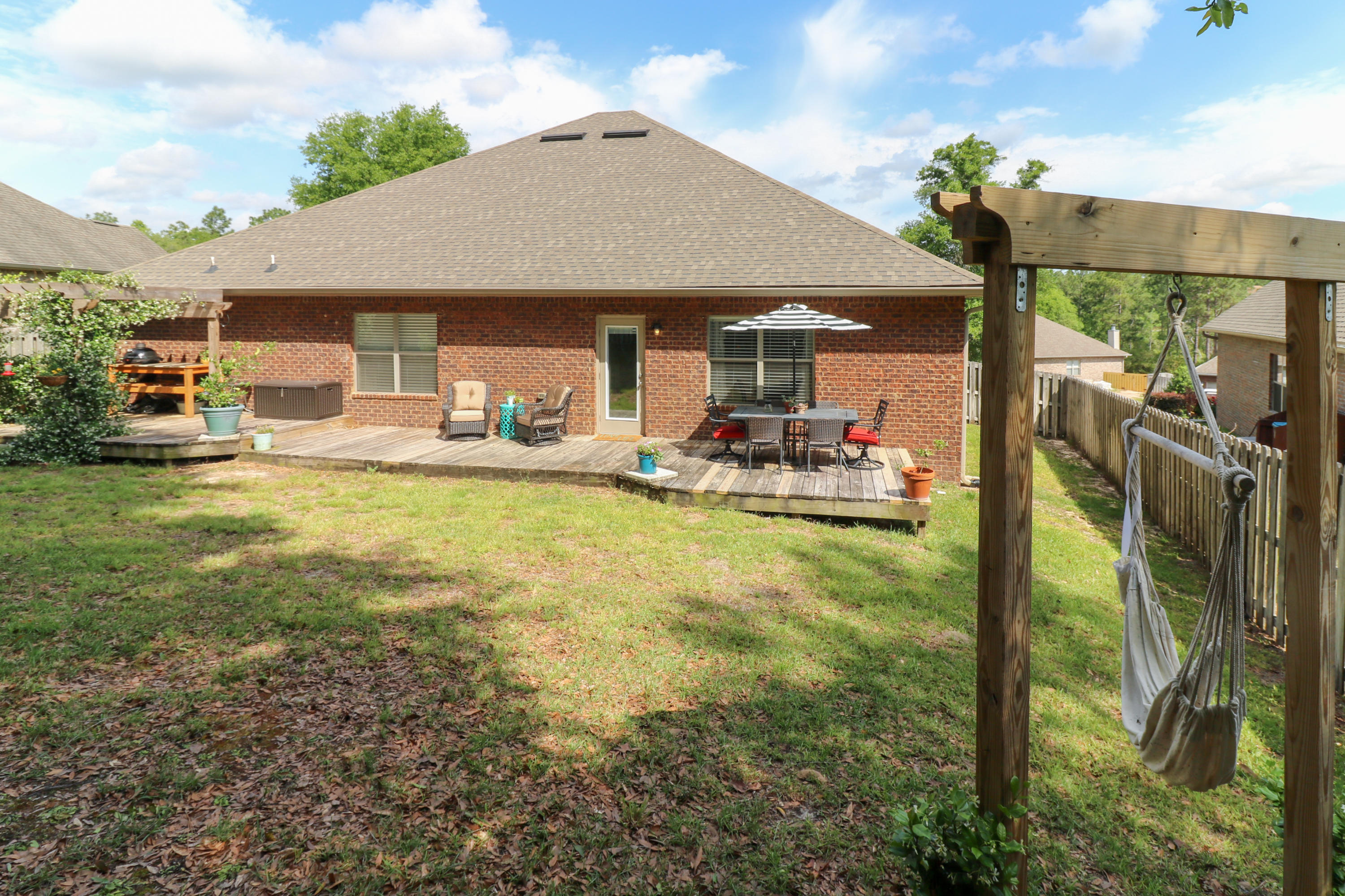 675 Red Fern Road Crestview, FL 32536 - Photo 35 of 35 a view of a patio with table and chairs under an umbrella