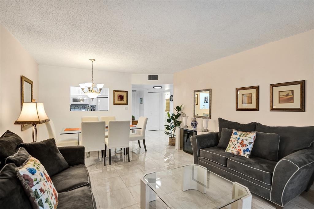 5681 Southwest 2nd Court, Unit 205 Margate, FL 33068 - Photo 12 of 37 a living room with furniture and a chandelier