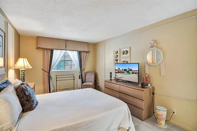 a bedroom with a bed and a large window