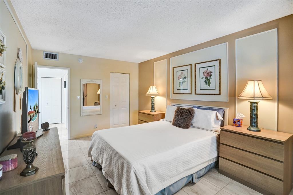 5681 Southwest 2nd Court, Unit 205 Margate, FL 33068 - Photo 15 of 37 a bedroom with a large bed and a lamp on dresser