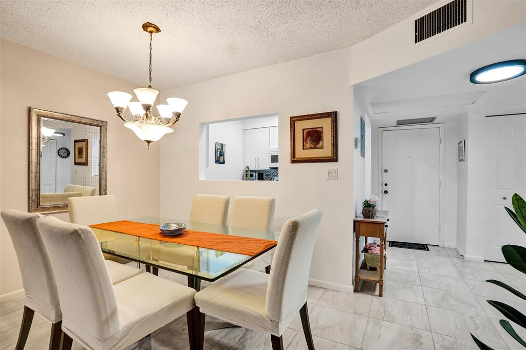 5681 Southwest 2nd Court, Unit 205 Margate, FL 33068 - Photo 3 of 37 a dining room with furniture a rug and a chandelier