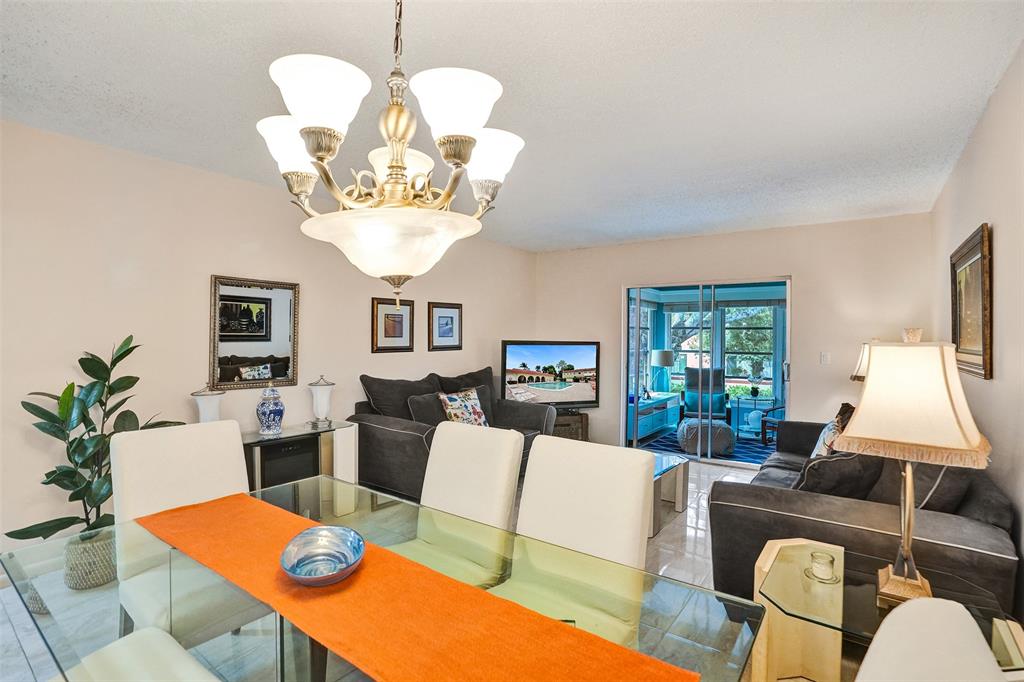 5681 Southwest 2nd Court, Unit 205 Margate, FL 33068 - Photo 4 of 37 a view of a dining room with furniture a chandelier and wooden floor
