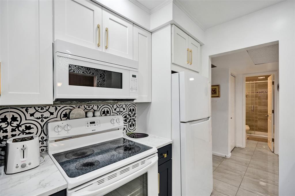 5681 Southwest 2nd Court, Unit 205 Margate, FL 33068 - Photo 6 of 37 a kitchen with white cabinets and white appliances