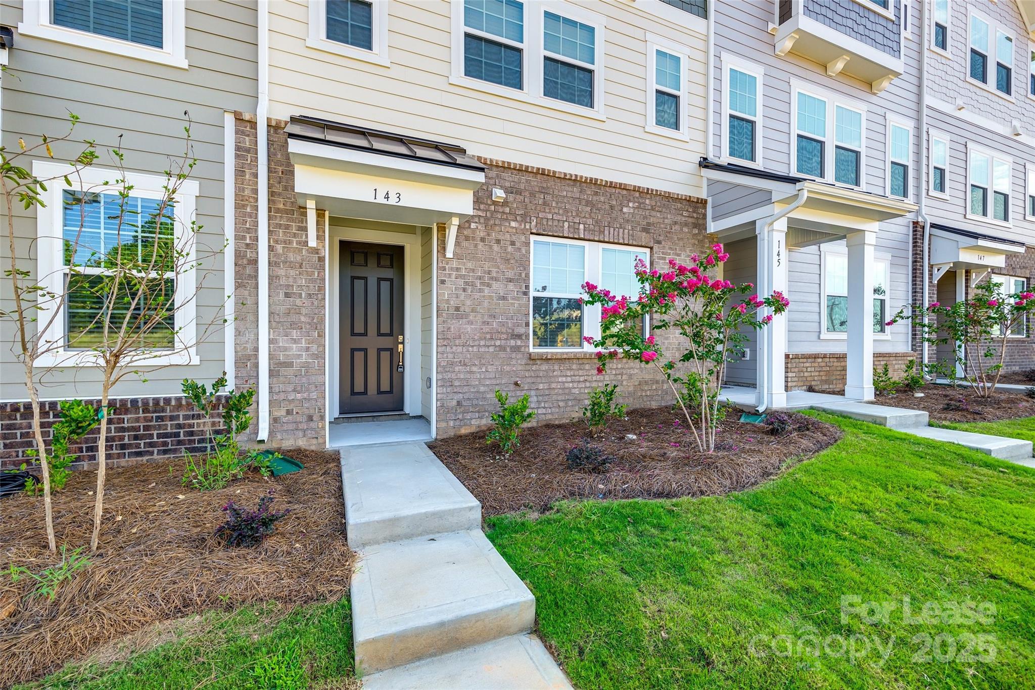 143 Morning Gap Parkway, Unit 14 Fort Mill, SC 29715 - Photo 2 of 30 a view of a house with brick walls and a yard with plants
