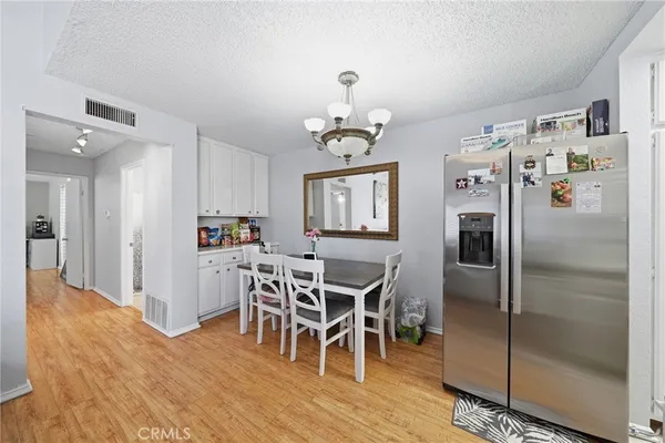 a kitchen with stainless steel appliances granite countertop a sink dishwasher stove and white cabinets with wooden floor