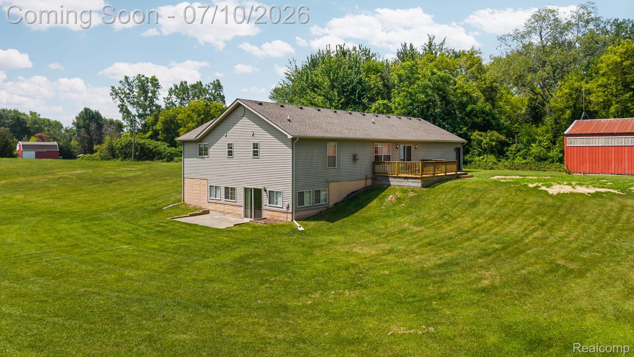 3144 North Nicholson Road Fowlerville, MI 48836 - Photo 8 of 70 Expansive green grounds featuring a two-story residence with a walk-out lower level and a rear deck